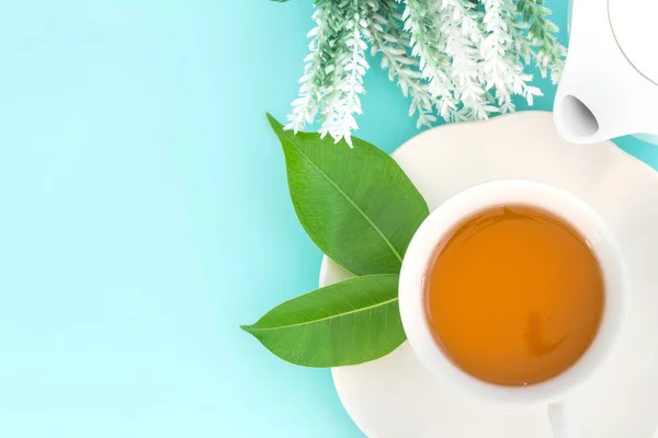 Vista superior de una taza de té caliente con hoja verde y flor en —  Fotos de Stock