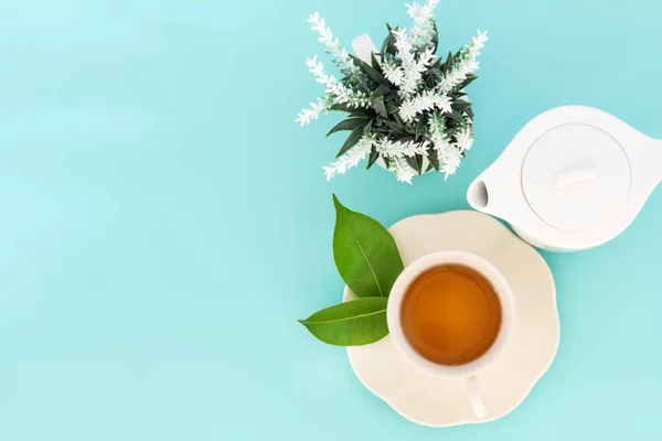 Vista superior de una taza de té caliente con hoja verde y flor en —  Fotos de Stock