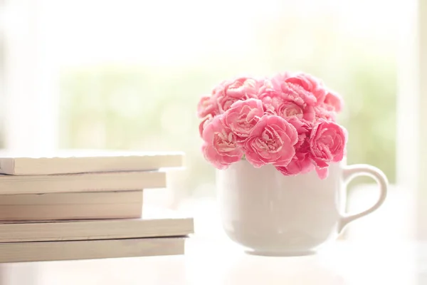 Fresh pink carnation flower with books background — Stock Photo, Image