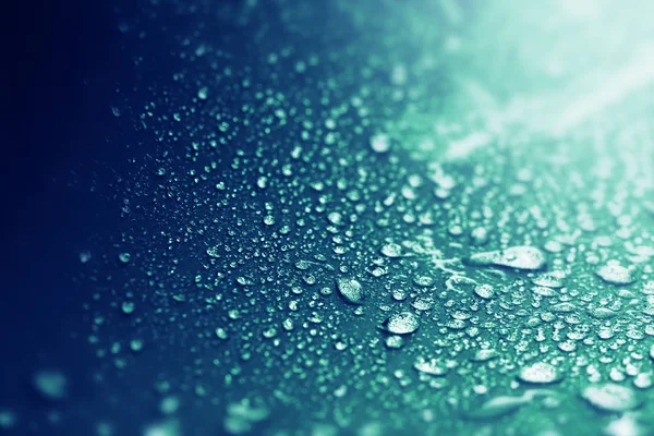Feche as gotas de água da chuva na superfície da esponja azul escura como abs — Fotografia de Stock