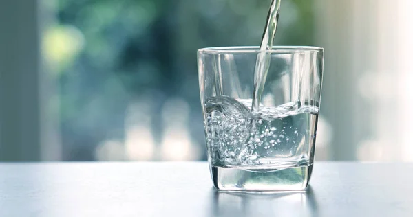 Крупним планом заливка очищеної свіжої питної води з пляшки — стокове фото