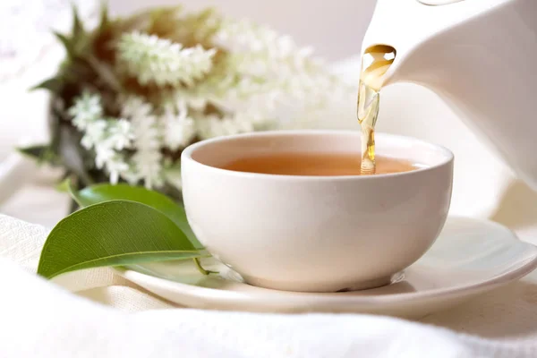 Nahaufnahme Einschenken von heißem schwarzen Tee in eine weiße Teetasse, Teezeremonie — Stockfoto