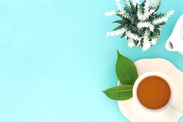 Aufnahme von oben einer heißen Tasse Tee mit grünem Blatt und Blume auf — Stockfoto