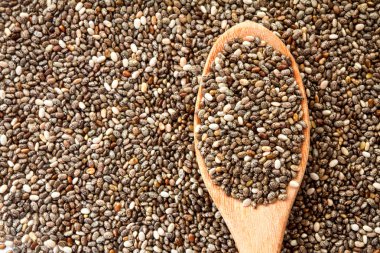 Tahta kaşık chia tohum arka plan üzerinde chia tohum kadar kapatın