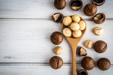 Beyaz ahşap arka plan, superfood Macadamia fındık kadar kapatın 