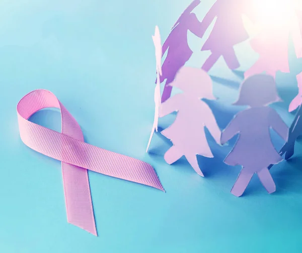 Kształt słodki różową wstążką z dziewczyna lalki papieru na niebieski backgro — Zdjęcie stockowe