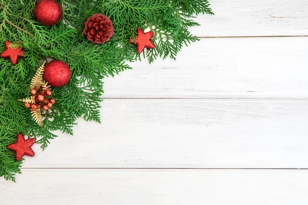 Borovice list s červenou hvězdou a vánoční dekorace koule na bílém — Stock fotografie