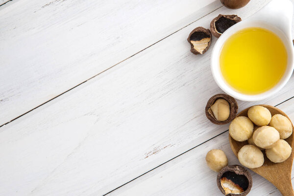 Close up almond oil in the bottle and almond seed in white cup f