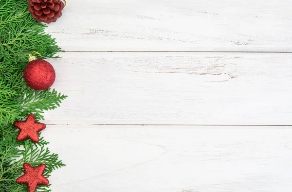 Pine list s červenou hvězdou a vánoční dekorace koule na w — Stock fotografie