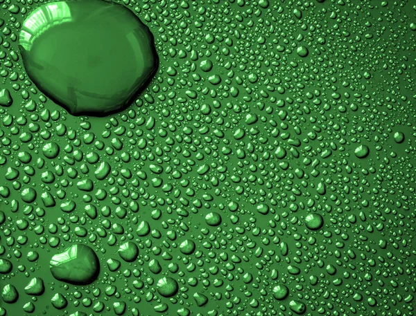 新鮮な緑の背景の表面に抽象的な水ドロップ — ストック写真