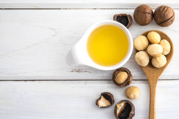 Close up almond oil in the bottle and almond seed in white cup f