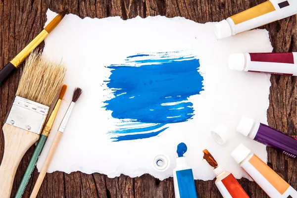 Resim fırçası ve mavi suluboya w üzerinde beyaz kağıt sanatı ile boyalı — Stok fotoğraf
