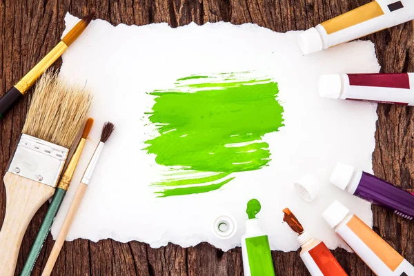 Resim fırçası ve yeşil suluboya ile beyaz kağıt sanat boyanmış — Stok fotoğraf