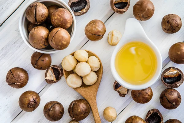  Macadamia fındık yağı ve soyulmuş macadamia fındık beyaz masa üzerinde ,