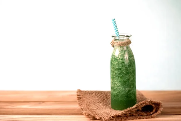 Ahşap üzerine cam şişede sağlıklı taze yeşil smoothie meyve suyu — Stok fotoğraf