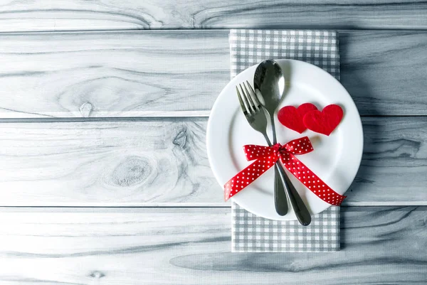 Red heart shape with White empty plate with fork and spoon on wo — Stock Photo, Image