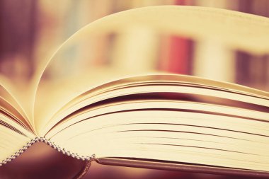 E için bulanık bookshelf arka plan ile açık kitap sayfa kapatın