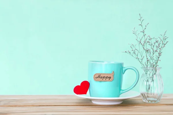 Hrnek kávový šálek s červené srdce shapeand šťastné slovo tag na dřevěné — Stock fotografie