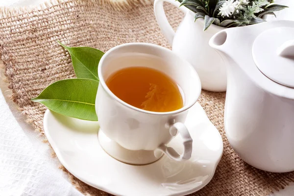 Cerrar té orgánico en taza blanca con hoja verde, ceremonia del té —  Fotos de Stock