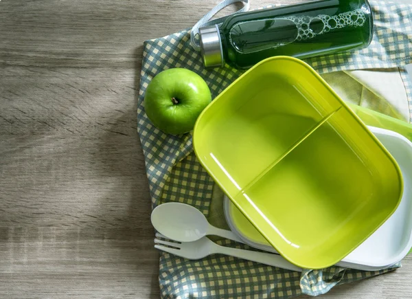 Een groene lege Lunchbox verpakt op houten tafel, bovenaanzicht of o — Stockfoto
