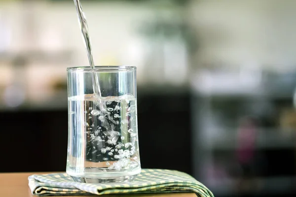 Il bicchiere dell'acqua purificata sul tavolo bar in cucina — Foto Stock