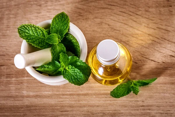 Aroma essential oil from a peppermint in the bottle on the table — Stock Photo, Image