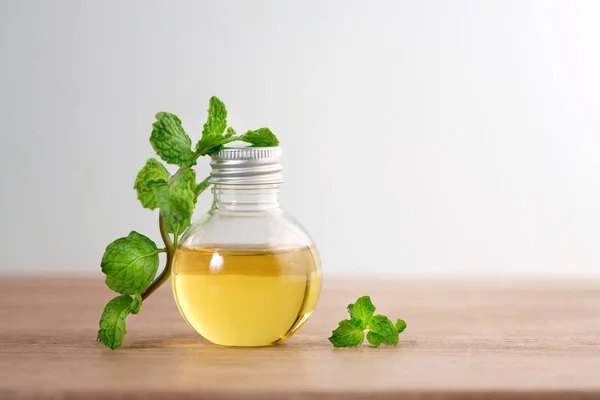 Aroma minyak esensial dari peppermint dalam botol di atas meja — Stok Foto