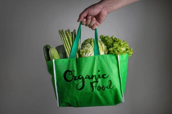 Close up a hand holding green grocery bag with Organic Food text — Stock Photo, Image