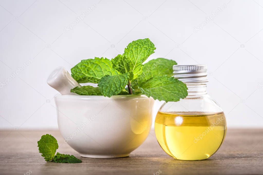 Aroma essential oil from a peppermint in the bottle on the table