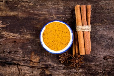 Kahverengi tarçın çubuğunu ve tozunu kapayın ve tahta zemin üzerinde kopyalama alanı olan Star Anise baharatıyla 
