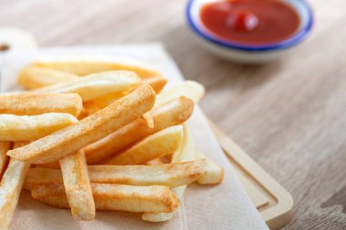 Masanın üzerinde domates sosu olan patates kızartmasını kapat.