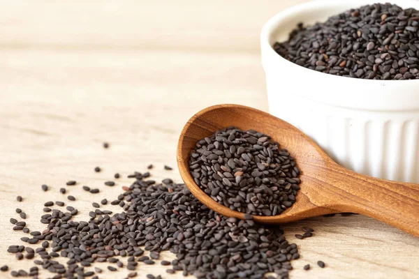Orgánico semillas de sésamo negro en cuchara de madera, alimentos saludables para —  Fotos de Stock