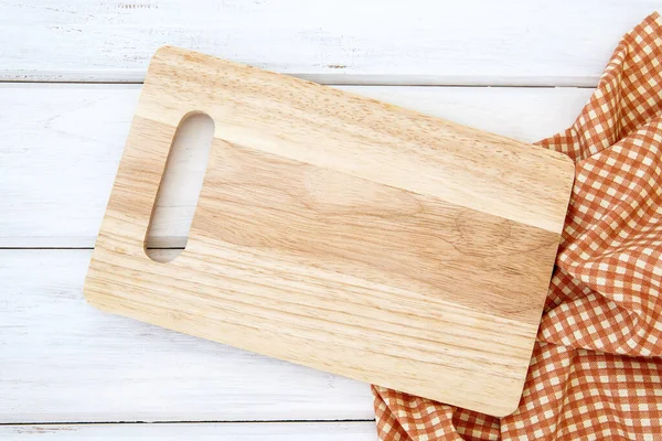 a chopping board and tablecloth on white table , recipes food