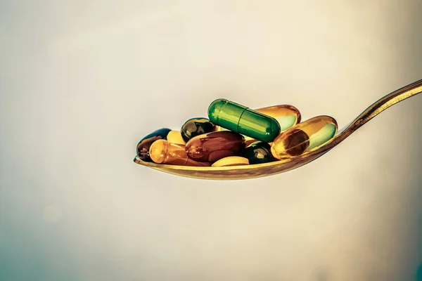 Die bunten medizinischen Nahrungsergänzungsmittel und Medikamentenpillen mit rotem Herz in — Stockfoto