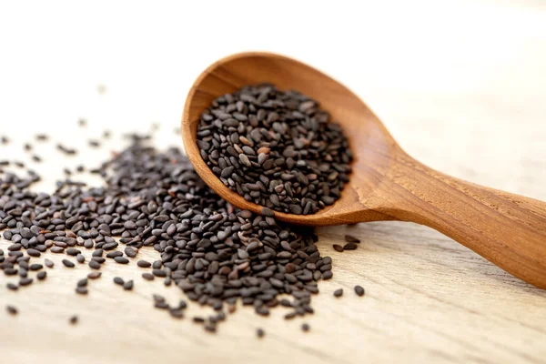 Bio černá sezamová semínka v dřevěné lžíci, zdravé krmivo pro — Stock fotografie