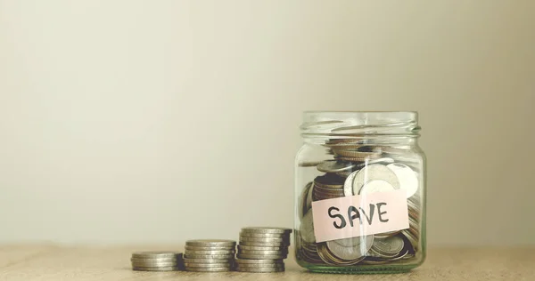Monete in vaso di vetro per risparmiare denaro concetto finanziario Fotografia Stock