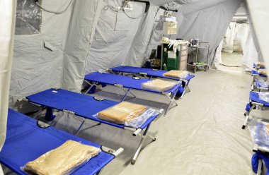 İlk AID için boş bir hastane çadırı, Corona Virüsü olan hastalar için mobil bir Kızıl Haç ünitesi. Salgın hastalık bulaşmış insanlar için katlanmış kamp yatağı olan iç kamp odası. 2019-ncov