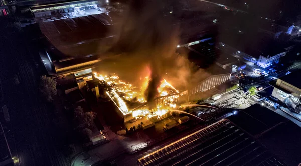 İnsansız hava aracı büyük bir endüstriyel fabrikada büyük bir gece yangını görüyor. İtfaiyeciler ve doktor yangını söndürmek ve kurbanlara yardım etmek için harekete geçti..