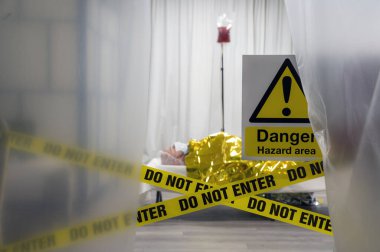 Covid-19 'u uyarın. Hastalıklı erkek hasta termal battaniye ve kan serumuyla laboratuvar kontrolleri sırasında acil serviste dinleniyor. Sarı bant, satır Girme, ön planda çapraz bant.