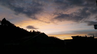 Karşıtlık el atardecer multicolor y la silueta de las casas de una pequea y tranquila ciudad.