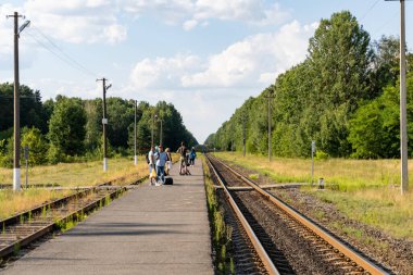İnsanlar trenin küçük bir taşra istasyonuna varmasını bekliyor..