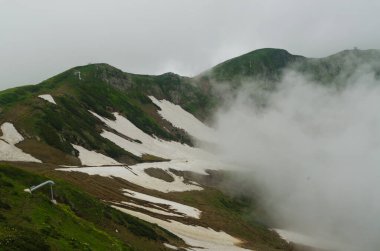 Yazın dağlarda kar, bulutlu hava