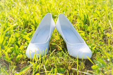 Çimlerin üzerinde kar beyazı düğün ayakkabıları