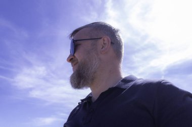 Yetişkin bir adam denize bakıyor.