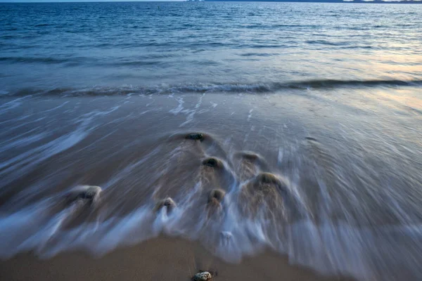 Uma Visão Noturna Mar Calmo Com Rochas Uma Praia — Fotografia de Stock