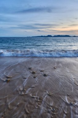 Sahilde kayaların olduğu sakin bir denizin akşam manzarası..