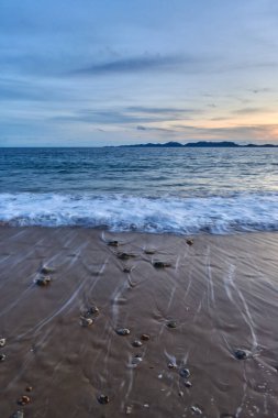 Sahilde kayaların olduğu sakin bir denizin akşam manzarası..