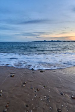 Sahilde kayaların olduğu sakin bir denizin akşam manzarası..
