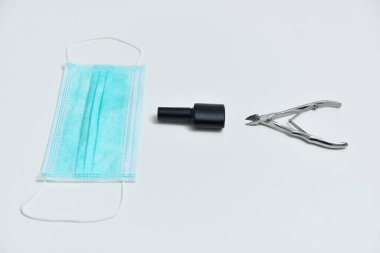 Jel cilası, tıbbi maske, manikür makası, tırnak törpüsü, koronavirüs ekipmanı konsepti. Coronavirüslü kolaj manikürü, 2019-nCoV. Jel cilası ekipmanları ve koronavirüs, COVID-19, 2019-nCoV.