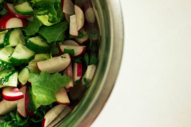 Salata, salatalık ve yeşil salata beyaz masada.